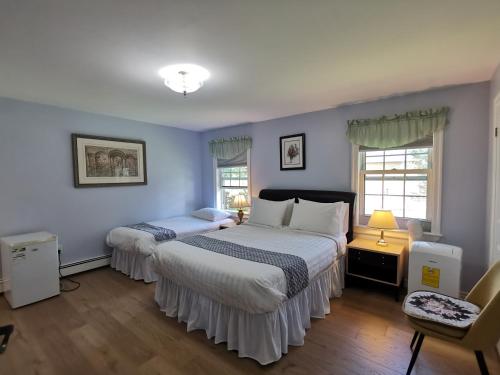 two beds in a bedroom with blue walls at Diana's Beauty House in Charlottetown