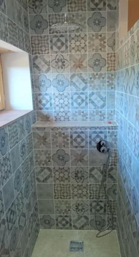La salle de bains est pourvue d'une douche et d'un mur en carrelage. dans l'établissement Bastide provençale au cœur de la Provence Verte, à Rians