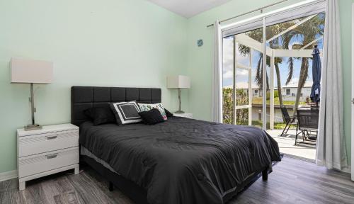 a bedroom with a bed and a large window at Private Pool, Spacious Kitchen, Backed Up To Canal in Cape Coral