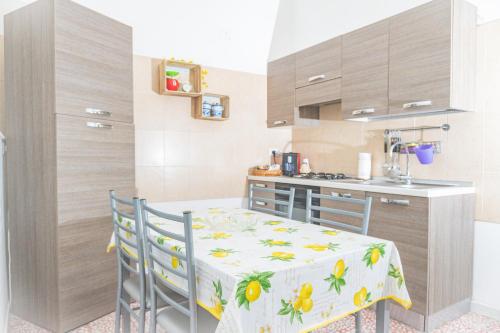 eine kleine Küche mit einem Tisch, Stühlen und einer Theke in der Unterkunft Casa Rosalba in Noto