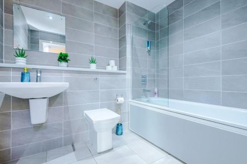 a bathroom with a sink and a toilet and a bath tub at Modern Central Manchester Serviced Apartment with 24-7 Gym Access in Manchester
