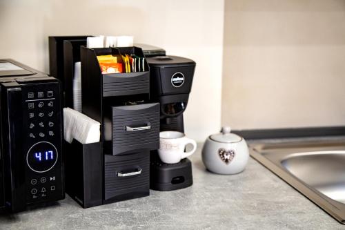eine Küchentheke mit Kaffeemaschine und Mikrowelle in der Unterkunft Fiore dei Templi - luxury suite experience in Agrigento