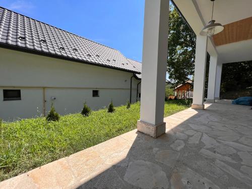 an empty porch of a white building with grass at Casa Maria Sarata Monteoru in Sărata-Monteoru