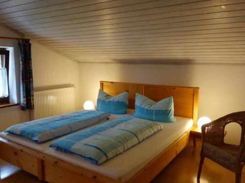 ein Schlafzimmer mit einem großen Bett mit blauen Kissen in der Unterkunft Ferienwohnung Obermeier in Grassau