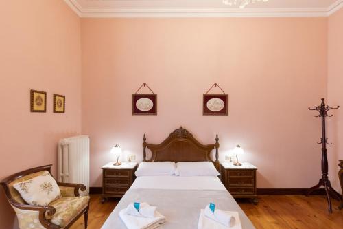 Un dormitorio con una cama grande y dos sillas. en Jauregi - baskeyrentals, en Lekeitio