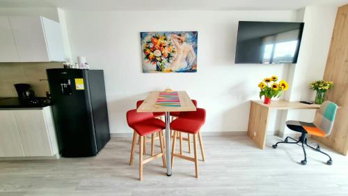 a kitchen with a table and chairs and a refrigerator at Toscana LOFT - Apartasuites in Bogotá