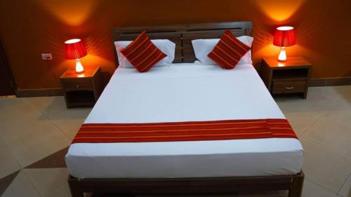 a bedroom with a large bed with two lamps at Luxury Beach Villa Inn in Dar es Salaam