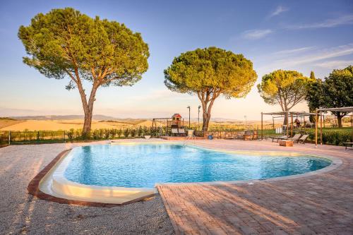 a swimming pool with trees and a playground at Orizzonti Toscani new apartment with view and pool in Laiatico