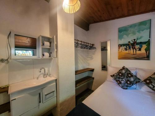 a small bedroom with a sink and a bed at Pousada Raiz Forte in Caraíva