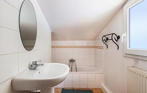 uma casa de banho branca com um lavatório e uma banheira em Les chambres de l'Issole em Cabasse