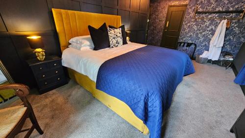 a bedroom with a large bed with a blue comforter at The Ribchester Arms in Blackburn