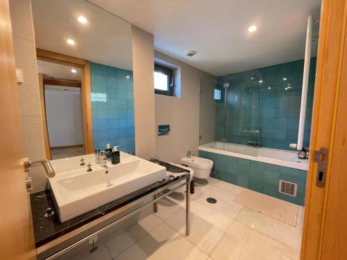 a bathroom with a sink and a tub and a toilet at Cascais Lux Apartment 521 letter in Cascais