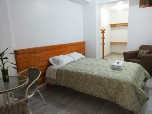 - une chambre avec un lit, une table et une chaise dans l'établissement Excelente ubicación! Bellas y cómodas habitaciones en el centro de Oxapampa, à Oxapampa
