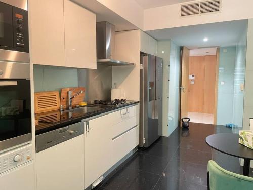 a kitchen with white cabinets and a black floor at Cascais Lux Apartment 521 letter in Cascais