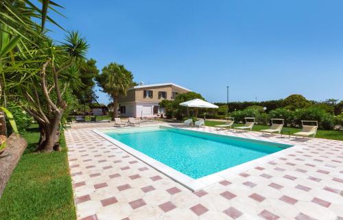una piscina en un patio con sillas y una casa en Al Giardino dell`Eden by BarbarHouse, en San Cataldo