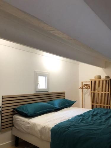 une chambre avec un lit avec des oreillers bleus dessus dans l'établissement T1 bis à proximité directe du village naturiste, au Cap d'Agde