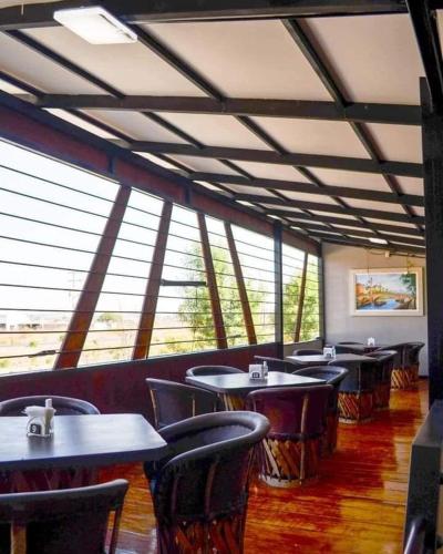 - une salle à manger avec des tables, des chaises et des fenêtres dans l'établissement Restaurant El Aventurero, à San Cristóbal