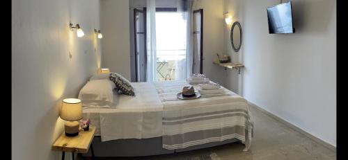 a bedroom with a bed with a table and a window at Mediterranean Hotel Blue sea in Corfu Town