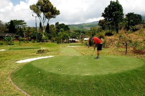 a man is playing golf on a golf course at Sari Ater Hotel & Resort in Ciater
