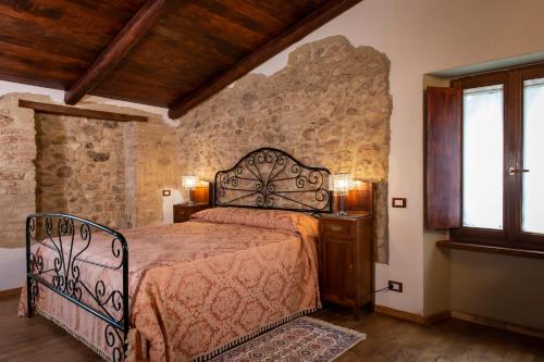 a bedroom with a bed and a stone wall at Volver B&B Spoleto in Spoleto