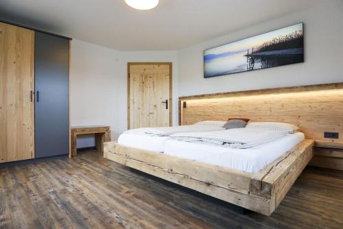 a bedroom with a large bed with a wooden headboard at Beim Lenglacher in Chieming