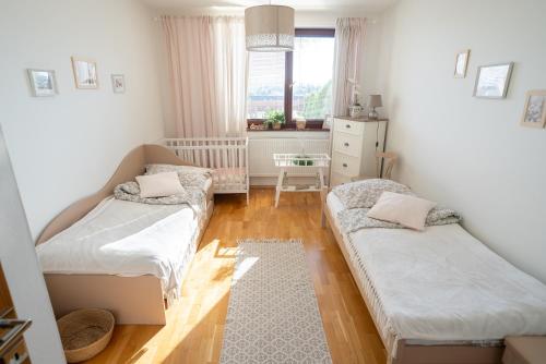 een kleine kamer met 2 bedden en een raam bij Apartmán NINA in Veľká Lomnica