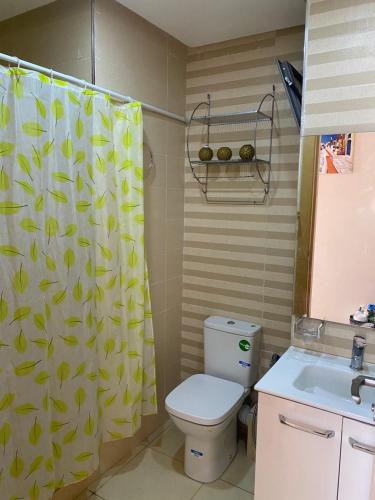 a bathroom with a toilet and a shower curtain at Appartement de charme in Kenitra