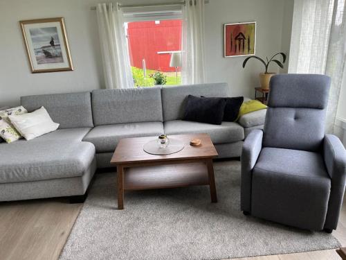 uma sala de estar com um sofá e uma cadeira em Sjarmerende gårdsbruk omgitt av vakker natur em Molde