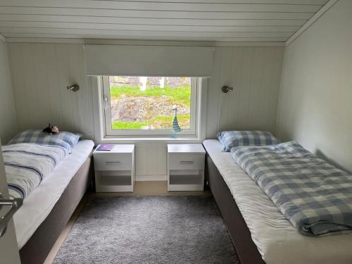 two beds in a room with a window at Sjarmerende og romslig bolig, omgitt av vakker natur in Molde