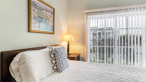 a bedroom with a bed and a large window at The Cliffside Resort Condominiums in Greenport