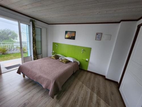 a bedroom with a bed with a green headboard at VILLA GRONDIN in Cilaos