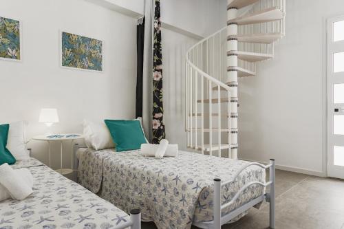 a bedroom with two beds and a spiral staircase at Casa Oceano Mare BIG in Pozzallo