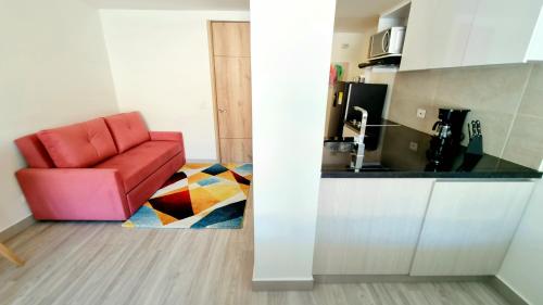 a red chair sitting in a kitchen next to a counter at Toscana LOFT - Apartasuites in Bogotá