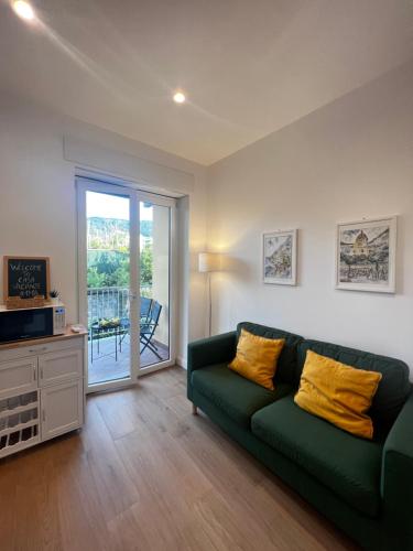 un soggiorno con divano verde e porta scorrevole in vetro di Casa Vacanze Imma a Sorrento