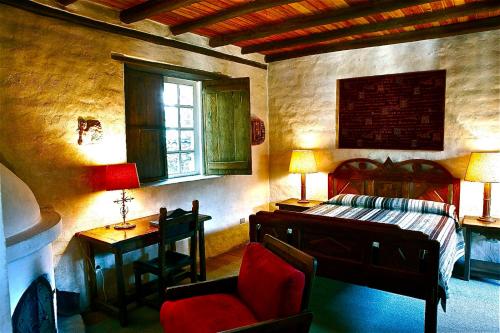 a bedroom with a bed and a desk and a chair at Hacienda Cusin in Otavalo