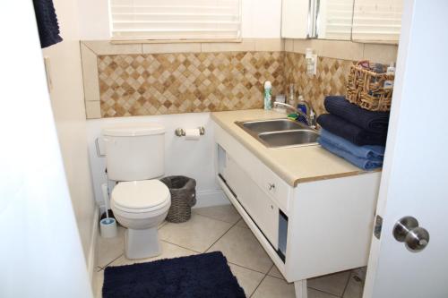a small bathroom with a toilet and a sink at Master King Suite by Hard rock stadium and casino in Miami