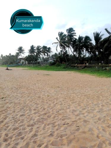 a sandy beach with palm trees in the background at Annasi Villa in Hikkaduwa