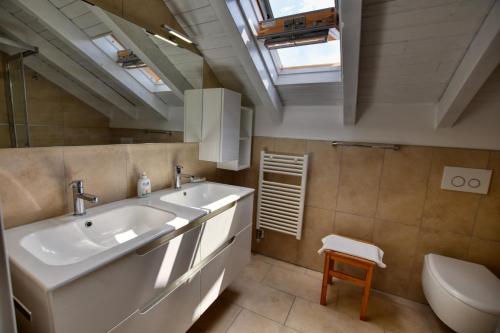 a bathroom with a sink and a toilet and a skylight at Villa Betty in San Siro