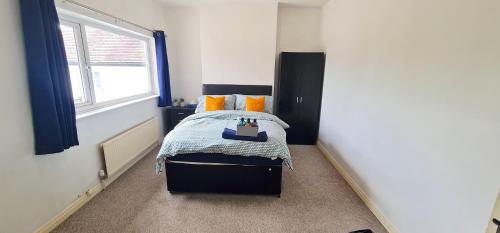 a bedroom with a bed with orange pillows and a window at Move inn Estates - Multiple Rooms in London