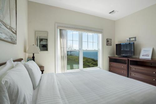 a bedroom with a bed and a large window at The Cliffside Resort Condominiums in Greenport