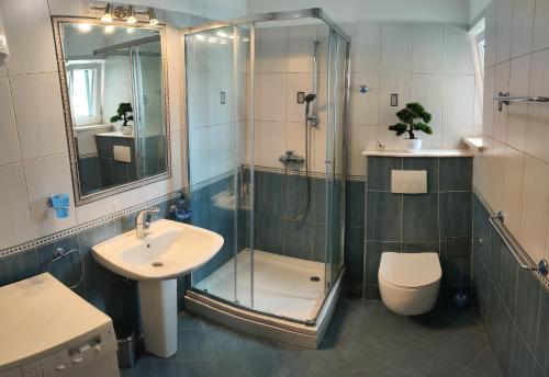 Un baño con ducha, inodoro y lavabo. en Beach Apartments Rogoznica, en Rogoznica
