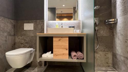 a bathroom with a white toilet and a sink at Frühstückspension Astoria in Sölden