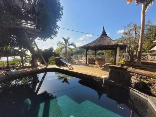 a pool at a resort with a gazebo at Villa Créolia in Saint-Leu