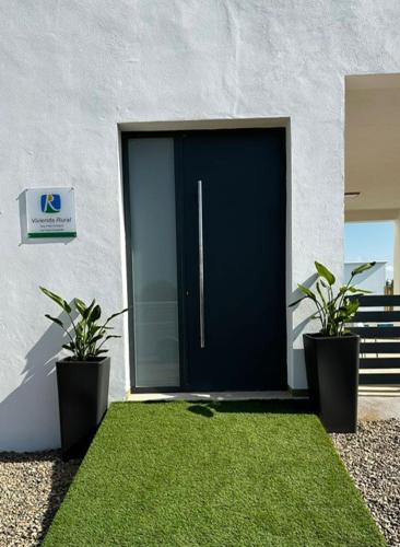 une porte avec deux plantes en pot devant un bâtiment dans l'établissement La casa grande village, 
