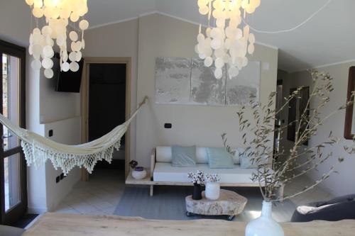 a living room with a couch and chandeliers at Villa CliCla - Pool, sea,hommock swing and laziness in Imperia