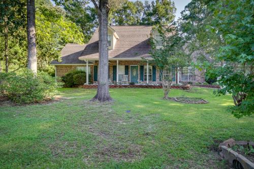 a house with a tree in the yard at Charming Diamondhead Home with Private Yard! in Diamondhead