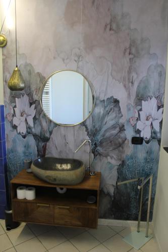 a bathroom with a sink and a mirror on a wall at Villa CliCla - Pool, sea,hommock swing and laziness in Imperia