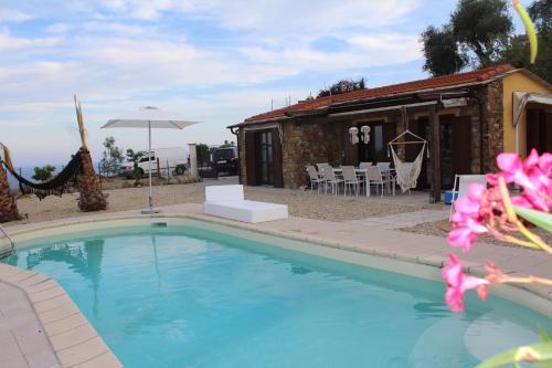 a swimming pool in front of a house at Villa CliCla - Pool, sea,hommock swing and laziness in Imperia