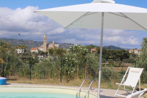 a chair and an umbrella next to a swimming pool at Villa CliCla - Pool, sea,hommock swing and laziness in Imperia