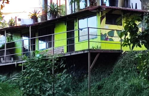 a yellow and green house on the side of a building at Romeo y Julieta, cabaña privada en Minca in Minca